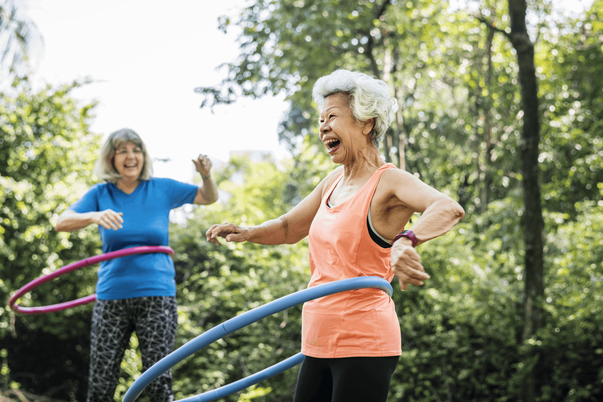 Elderly ladies smiling and enjoying a fun workout with hula hoops